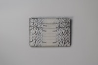 an alligator skin card holder on a white surface